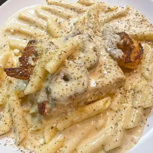 Dat Dam Salmon served with shrimp over a bed of penne noodles with choice of white wine cheese sauce 
or red cajun sauce