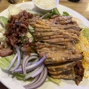 Grilled chicken salad with a wing sauce on it makes a great meal