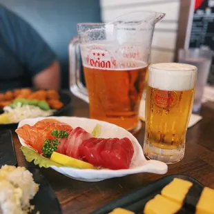 a plate of sushi and a glass of beer