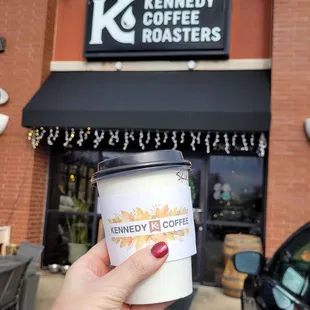 a hand holding a cup of coffee