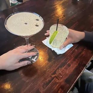 two people sitting at a table with drinks