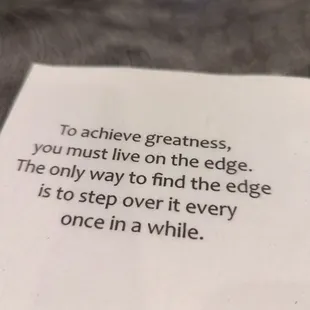 a piece of paper with the quote to achieve greatness, you must live on the