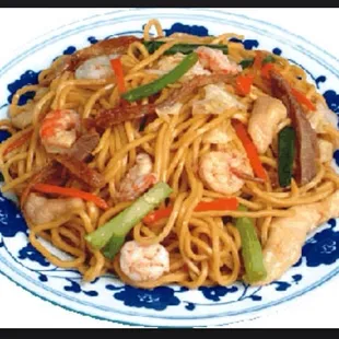 a plate of noodles with shrimp and vegetables