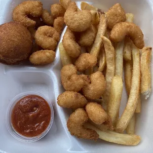 Popcorn shrimp with homemade cocktail sauce, fries, and a puff.