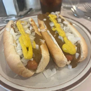 two hot dogs with mustard and onions
