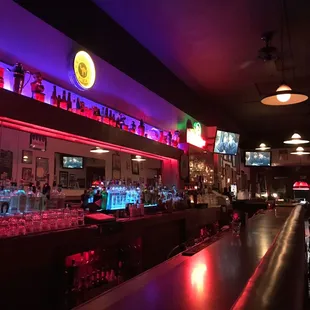 a bar with neon lights and bar stools