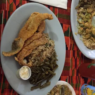 Fried fish with vegetable rice and green beans. Also featuring a partially demolished small plate of chicken curry.