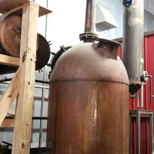 a man standing in front of a copper pot