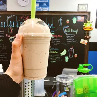 a hand holding a smoothie