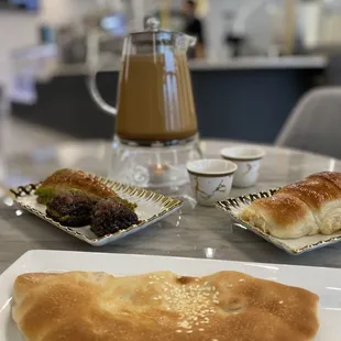 Mofawar coffee (large pot), baklava, cinnamon chocolate pastry, and a turkey and cheese pastry.