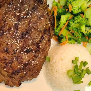 a steak, rice, and broccoli on a plate