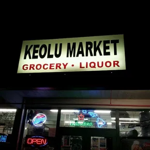 a neon sign for a grocery liquor store