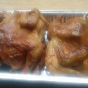 two roast chickens in a foil pan