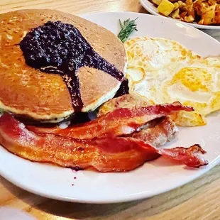 a breakfast of pancakes, bacon and eggs