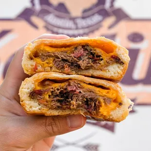 a hand holding a half eaten sandwich