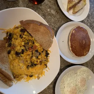 A sampling of the menu.  One piece of French toast, one pancake, two eggs, SPOD &apos;Fiesta Skillet&apos; and coffee