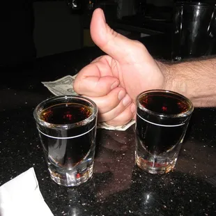 two shot glasses of alcohol on a counter