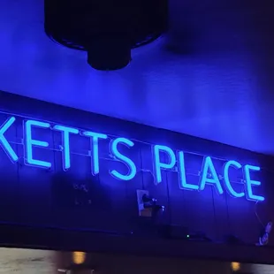 a neon sign above a bar