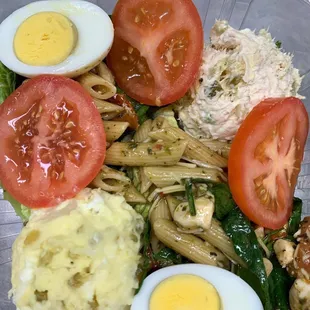 a plate of food consisting of pasta, eggs, tomatoes, and spinach