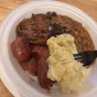 Sliced brisket, sausage, and baked beans. Potato salad is homemade