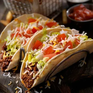 three tacos on a cutting board