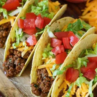 three tacos on a cutting board