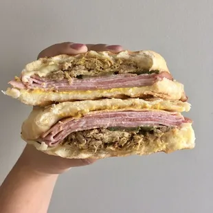 a hand holding a sandwich