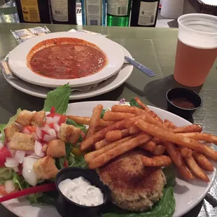 Crab cake platter with slaw, salad, and fries.