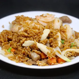 a plate of fried rice with shrimp and vegetables