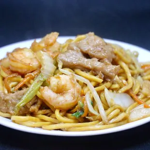 a plate of noodles with meat and vegetables