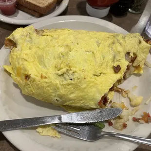 an omelet on a plate with a knife and fork