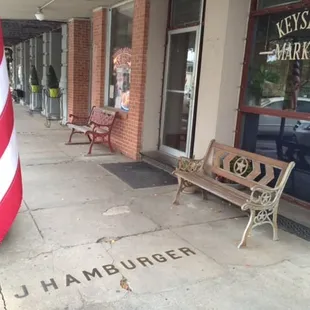 a bench and a flag on the sidewalk