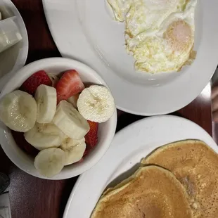 a breakfast of pancakes, fruit, and eggs