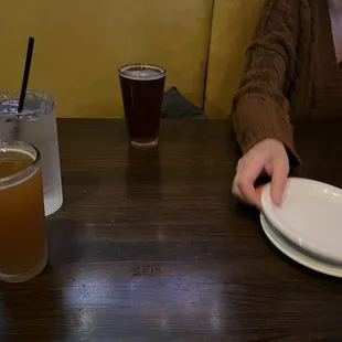 a woman sitting at a table with a plate and a drink