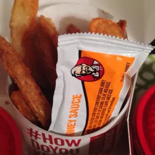 Potato wedges are delish but look how tiny the portion is. That's a small honey packet stuck in there for reference!