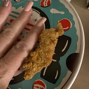 Overcooked chicken tender that is the size of a small petite hand (index finger).