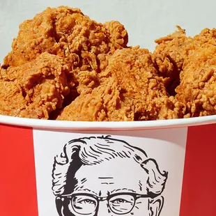 a bucket of fried chicken with a drawing of a woman&apos;s face