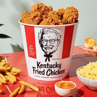 a bucket of fried chicken and a bowl of macaroni and cheese fries