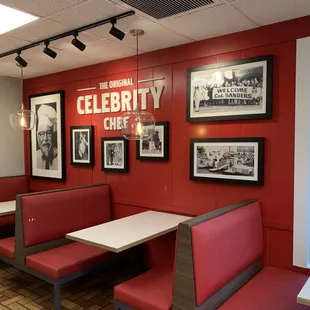 a restaurant with red booths and pictures on the wall
