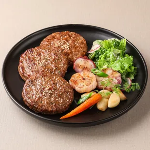 a steak and vegetables on a black plate