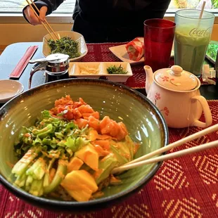 Salmon and Tuna Poke bowl, green tea, seaweed salad, sushi burrito, and Pakota milk shake