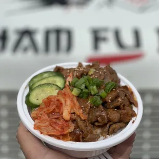 a person holding a bowl of food