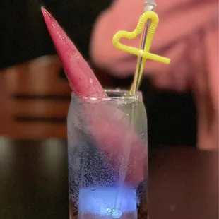 a glass of water with ice and a straw in it
