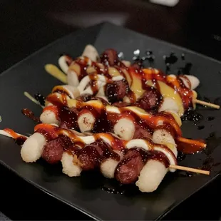 a plate of skewers of food