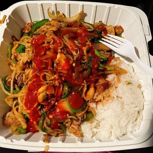 a take out container with rice and vegetables