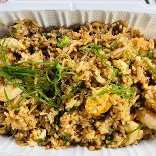 a close up of a rice dish in a styrofoam container