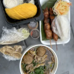 Thai boat , chicken skewers , mango sticky rice with coconut dessert , and papaya salad
