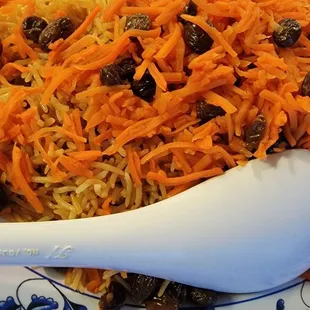 a plate of food with carrots and raisins