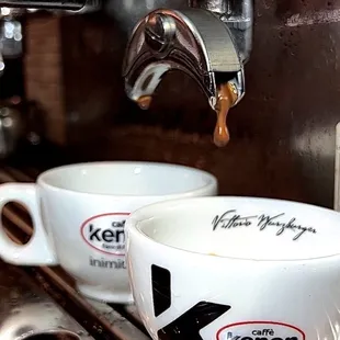 coffee being poured into two cups