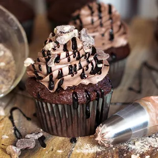 a chocolate cupcake with chocolate frosting and sprinkles